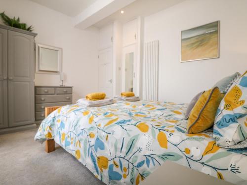 a bedroom with a bed with a colorful comforter at Sea Breeze in Marazion