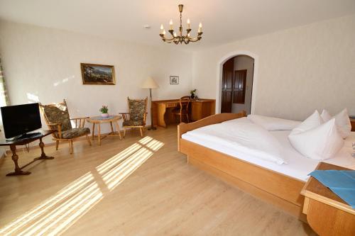a bedroom with a bed and a desk with a computer at Gasthof Oberwirt in Ramsau