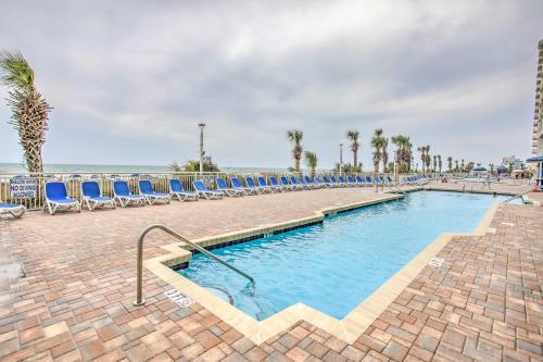 a swimming pool with chairs and the ocean in the background at Ocean-View Balcony North Myrtle Beach Condo! in Myrtle Beach