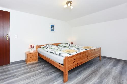 カロリーネンジールにあるPension Pradler Zimmer Erdgeschoßの木製のベッドフレームが備わるドミトリールームのベッド1台分です。