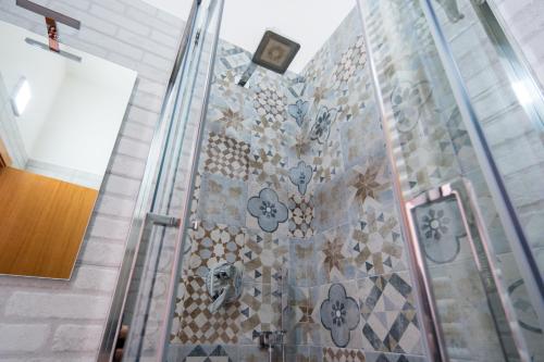 uma casa de banho com uma parede de azulejos com um relógio em Agriturismo Le Matinelle em Matera