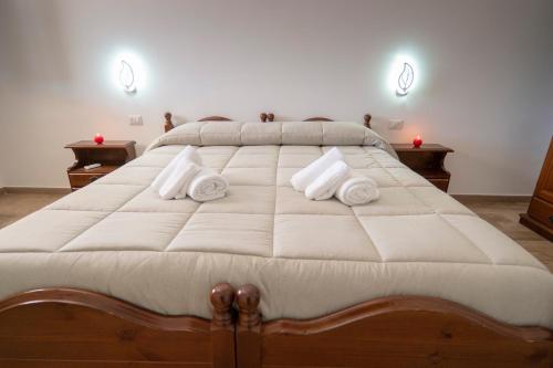 uma cama grande com lençóis brancos e toalhas em Agriturismo Le Matinelle em Matera