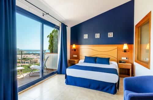 a hotel room with a bed and a balcony at Hotel Garbi in Calella de Palafrugell