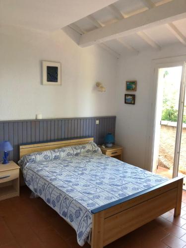 um quarto com uma cama com um edredão azul em Villa avec piscine au Lavandou dans jardin méditerranéen em Le Lavandou