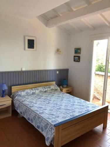 une chambre avec un lit avec une couette bleue dans l'établissement Villa avec piscine au Lavandou dans jardin méditerranéen, au Lavandou