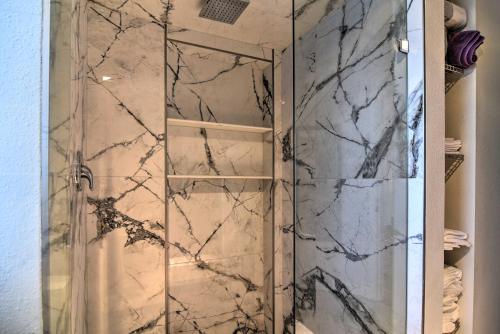 a shower with marble walls and a glass door at Vibrant Dunedin Getaway with Furnished Patio! in Dunedin