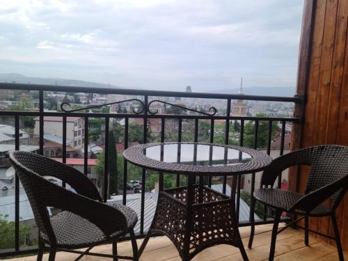 a table and chairs on a balcony with a view at Honeymoon Apartments in Old Tbilisi in Tbilisi City