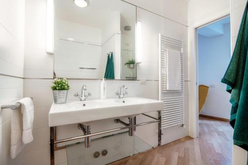 Un baño blanco con lavabo y espejo. en Vicolo Dei Pescatori - by MyHomeInComo, en Argegno