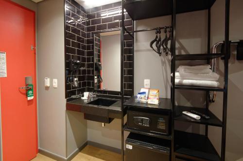 a bathroom with a sink and a mirror at Golden Tower Express Berrini by Fênix Hotéis in Sao Paulo