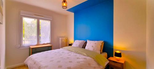 Un dormitorio con una pared de acento azul y una cama en Le Douillet par Picardie Homes en Crouy