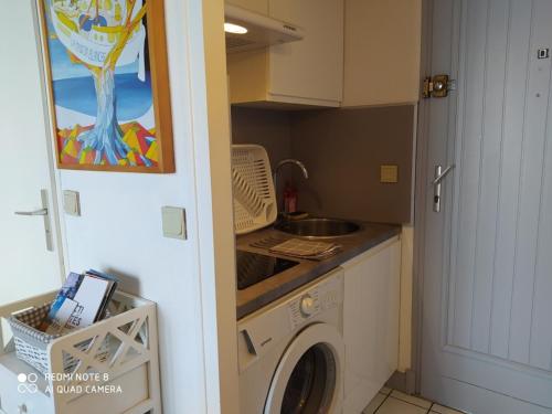 a kitchen with a washing machine and a sink at Royan - Agréable Duplex Plage de Nauzan in Vaux-sur-Mer