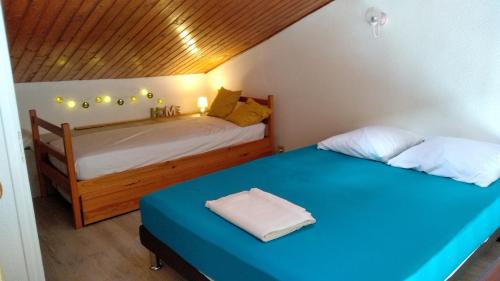 two beds in a small room with a blue bed at Royan - Agréable Duplex Plage de Nauzan in Vaux-sur-Mer