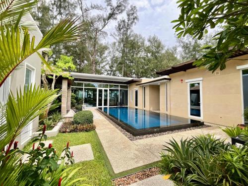 Sunset Ocean Front Villa , Mai Khao Phuket في شاطئ ماي خاو: مسبح في الحديقة الخلفية للمنزل