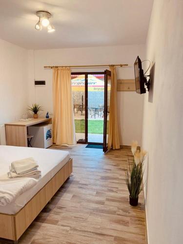 a bedroom with a bed and a door to a patio at Casa Ella in 2 Mai