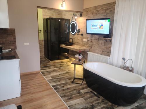 a bathroom with a tub and a tv on the wall at Honeymoon Apartments in Old Tbilisi in Tbilisi City