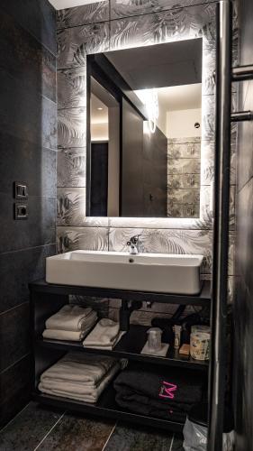 a bathroom with a sink and a mirror and towels at My Suite Hotel in LʼAquila