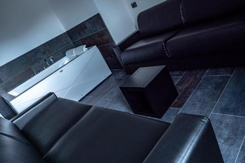 a living room with a black couch and a table at My Suite Hotel in LʼAquila