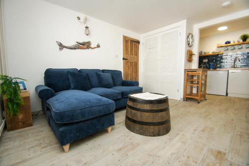a living room with a blue couch and a barrel at Mermaid Cottage - Wood Burner- by Brighton Holiday Lets in Brighton & Hove