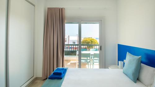 Un dormitorio con una cama grande y un balcón. en Blancazul El Marisco, en Playa Blanca