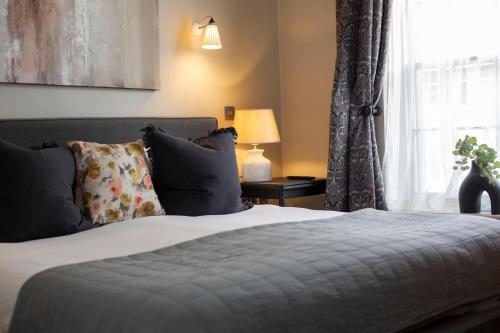 a bedroom with a large bed with a window at The Grosvenor Arms in Shaftesbury