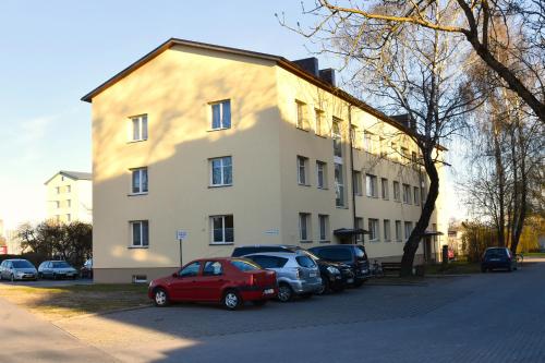 a building with cars parked in front of it at Kristella Kesklinna Apartment in Haapsalu