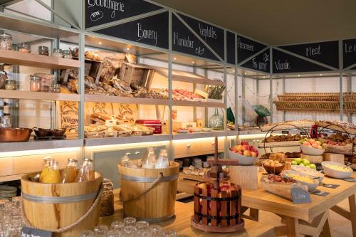 a bakery with a counter with lots of food at Le Grand Pavillon Chantilly in Chantilly