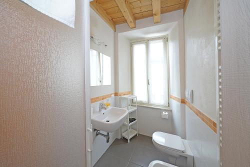 Baño blanco con lavabo y aseo en B&B San Rocco, en Gargnano