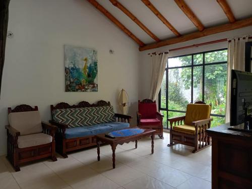 sala de estar con sofá y 2 sillas en El Nido de Paso, en Tibasosa