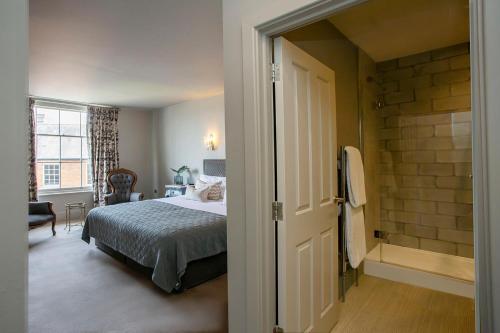 a bedroom with a bed and a walk in shower at The Grosvenor Arms in Shaftesbury