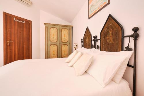 a bedroom with a white bed with white pillows at La Villetta in Pula