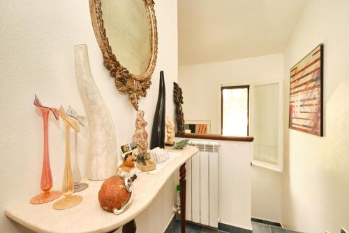 a room with a shelf with vases and a mirror at La Villetta in Pula