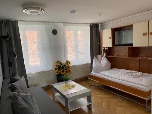 ein Wohnzimmer mit einem Bett und einem Tisch in der Unterkunft Ferienwohnung Nikolaiblick in Jüterbog