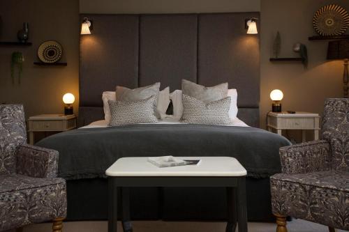 a bedroom with a large bed with two chairs at The Grosvenor Arms in Shaftesbury