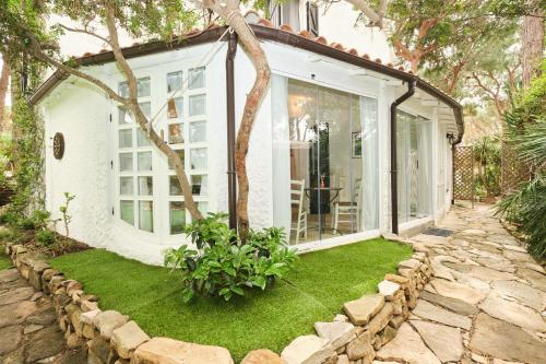 a small white house with a window and green grass at La Villetta in Pula