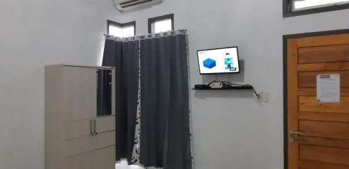 a room with a black curtain and a television at Cahaya kos putri in Banda Aceh