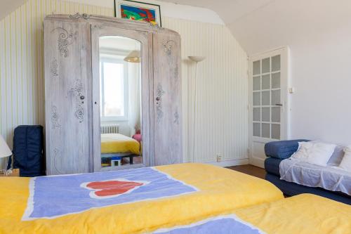 a bedroom with a large mirror and a bed at Au coeur de Tréffiagat - maison pour 6 - 300m de la plage in Tréffiagat