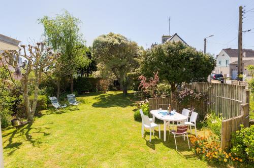 a garden with a table and chairs and a fence at Au coeur de Tréffiagat - maison pour 6 - 300m de la plage in Tréffiagat
