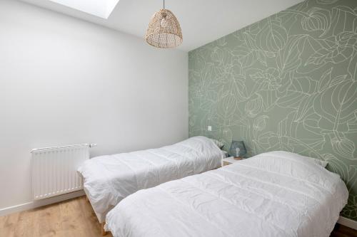 - une chambre avec 2 lits et un mur vert dans l'établissement Maison pour 6 personnes à Saint Michel Chef Chef, à Saint-Michel-Chef-Chef