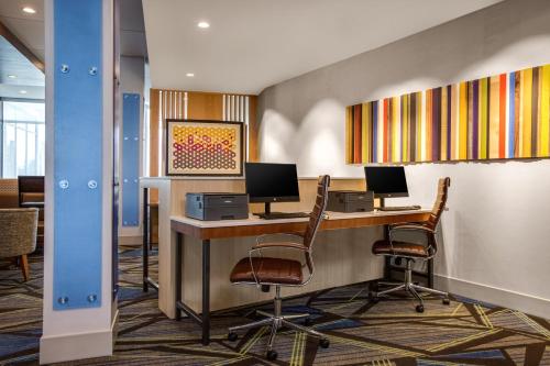 an office with a desk with two monitors and chairs at Holiday Inn Express & Suites Sanford - Lake Mary by IHG in Sanford