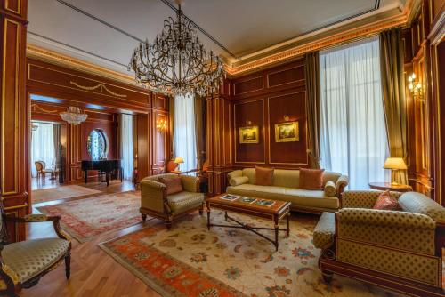 sala de estar con sofá, sillas y lámpara de araña en Grand Hotel Wagner, en Palermo