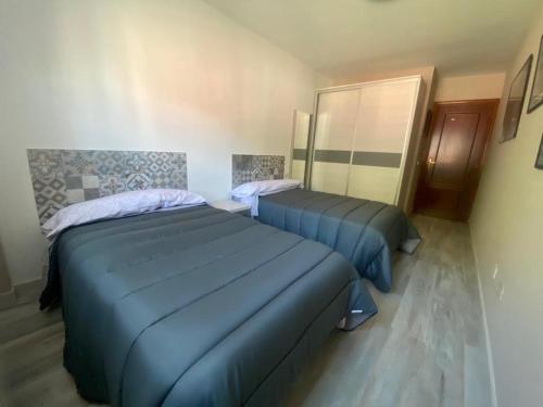 - 2 lits dans une chambre avec des draps bleus dans l'établissement APARTAMENTO TURIETO (BROTO-ORDESA), à Broto
