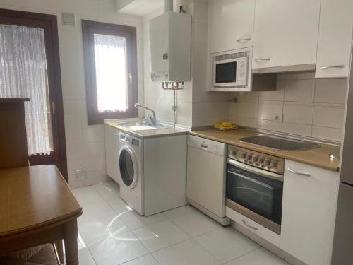 a kitchen with a sink and a washing machine at APARTAMENTO TURIETO (BROTO-ORDESA) in Broto