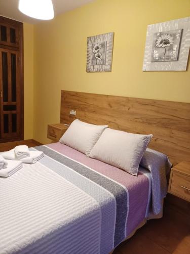a bedroom with a bed with two towels on it at Alojamientos turísticos Sinagoga in Úbeda