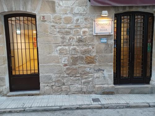 a building with two doors and a sign on it at Alojamientos turísticos Sinagoga in Úbeda