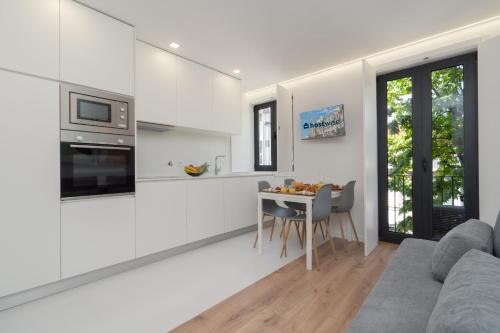 a white living room with a couch and a table at Host Wise - Bright & Contemporary Flat - Ace Location in Porto