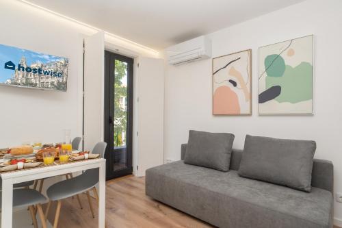 a living room with a couch and a table with food on it at Host Wise - Bright & Contemporary Flat - Ace Location in Porto