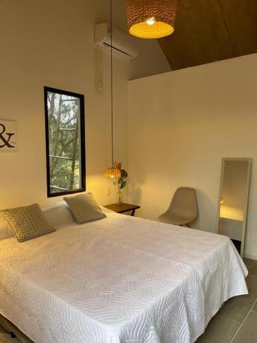 a bedroom with a white bed and a window at VILLA MORA Punta Colorada in Punta Colorada
