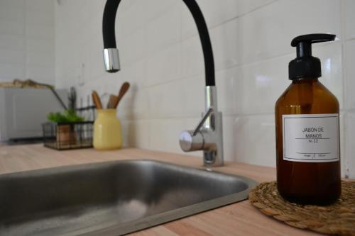 una bottiglia di salsa mista seduta accanto al lavandino della cucina di VILLA MORA Punta Colorada a Punta Colorada