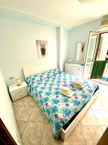 a bedroom with a bed with a comforter on it at La casa del pescatore in Scilla