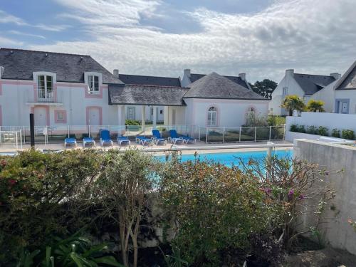 - une vue sur une maison avec une piscine dans l'établissement Maison de vacances de 56 m2 dans résidence avec piscine chauffée proche plages, à Locmaria